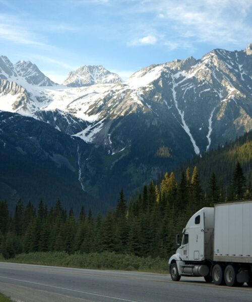 semi truck on road with mountains in background