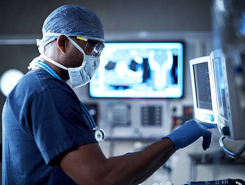 Shot of a surgeon looking at a monitor in an operating room Shot of a surgeon looking at a monitor in an operating room